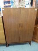 A retro G Plan style small or child's wardrobe with shelves and drawers within (H137 x W91 x D46cm)