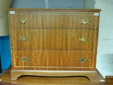 A crossbanded chest of three graduated drawers (H67 x W81 x D46cm)
