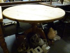 A circular scrubbed pine table,