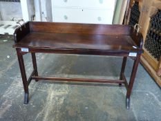 A small mahogany child's bench with splayed legs united by H stretcher and brass carry handles,