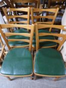 A set of four beech kitchen chairs with green seats