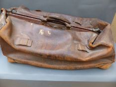 A vintage leather Gladstone bag with brass fittings