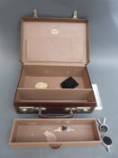 A small doctor's leather suitcase containing stethoscope diaphragm including one with teaching