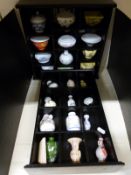 A collection of miniature vases on two display shelves