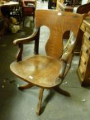 A vintage oak office or captain's chair with wrought iron mechanism enabling height and tilt