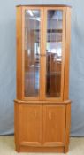 A retro G Plan glazed corner cupboard with three glass shelves and two door cupboard arrangement