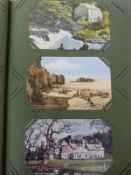 An Edwardian postcard album with colour and black and white postcards,