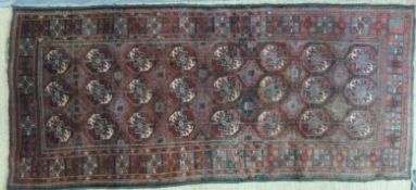 An Afghan rug or runner with multiple guls on a red ground (280 x 122cm)