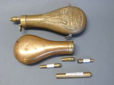 Two copper and brass powder flasks one with embossed decoration of cannon,