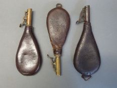 Three leather and brass shot flasks one by W Bartram, one by G & J W Hawksley and one unnamed,