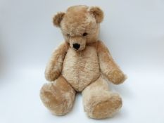 A large blonde mohair Teddy bear with glass eyes, shaved pads,