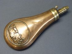 Copper and brass powder flask with embossed decoration of a man and two dogs, stamped 'patent',
