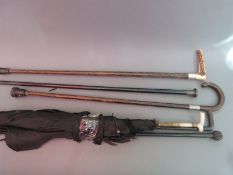 Three hallmarked silver-mounted walking sticks/canes and three various parasols