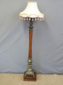An ornate brass and mahogany standard lamp the brass sections depicting horses and rococo swags