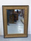 A mirror in ebonised frame with gilt decoration,
