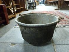 An antique copper cooking pot with iron handle,