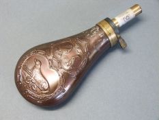 Copper and brass powder flask with embossed decoration of a dog and two birds surrounded by an