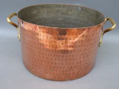 A large heavy beaten copper two handled pan, 37cm diameter,