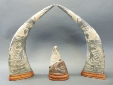 A pair of large carved horns and another carved in the form of a bird