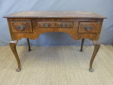 An early 20thC walnut desk raised on cabriole legs,