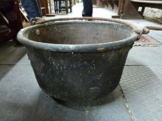 An antique copper cooking pot with iron handle,