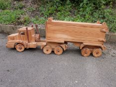 A large wooden model of a lorry with opening back doors and working steering,