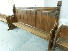 A 19thC oak church pew with panelled back and carved finials, ex St Bartholomew's Church, Cam,