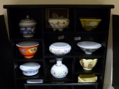 A collection of miniature vases on two display shelves