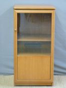 A retro hi-fi or similar cabinet with part glazed door,