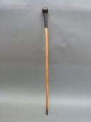 A walking cane with stitched leather knop