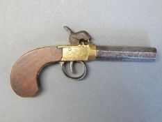 Percussion hammer action pistol with engraved and floral stamped brass lock, walnut grip,