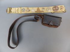 A military trophy belt with various original cap badges,