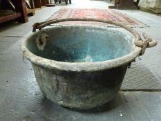 An antique copper cooking pot with iron handle,
