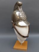 A nickel fireman's helmet with crossed axe emblem to front