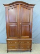 A modern panelled wardrobe with four drawers to base,