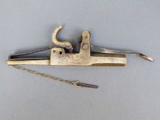 A brass alarm gun with steel pin on chain and two inch octagonal barrel, overall length 20cm.