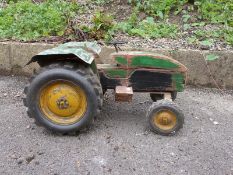 A large scale wooden model of a John Deere tractor with green body and yellow wheels,