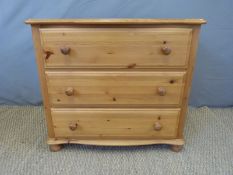 A serpentine topped pine chest of three drawers,