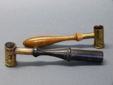 Two brass shot/ powder measures both with turned wooden handles, largest 14.5cm long.