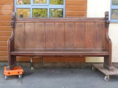 A late 19thC panelled oak pew with carved decoration to ends, L258 x D47 x H149cm,