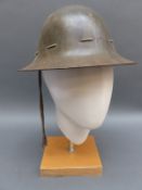 A WWII military helmet dated to liner 1941 and stamped to rim M and KH and a WWII Fire Guard helmet