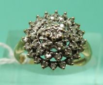 A 9ct gold ring set with diamonds in a tiered cluster, total diamond weight 0.