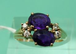 A 9ct gold ring set with two oval mixed cut amethysts and diamonds (size M)