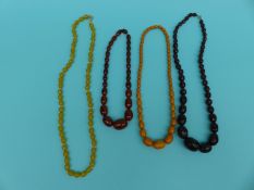 Four necklaces including faceted cherry amber, glass,
