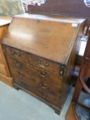 A mahogany bureau, the fall flap revealing fitted interior, the base fitted two over three drawers,