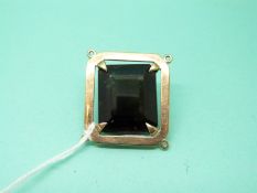 A yellow metal pendant set with a large emerald cut smoky quartz