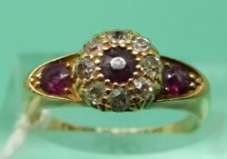 An 18ct gold ring set with three round cut rubies and old cut diamonds,