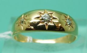 An 18ct gold ring set with three diamonds in star settings (size L), weight 3.