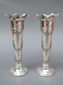 A pair of Edward VII hallmarked silver trumpet or spill vases with embossed decoration,.