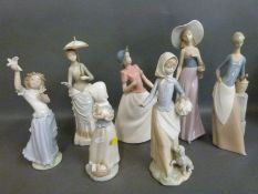 A collection of Nao figurines including girls with baskets, puppy, flowers,